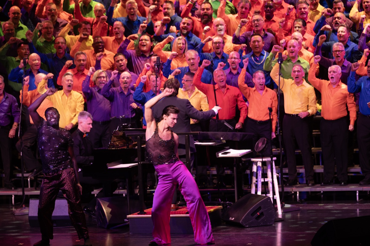GMCSF singers in bright Pride colors performing with dancers on stage.